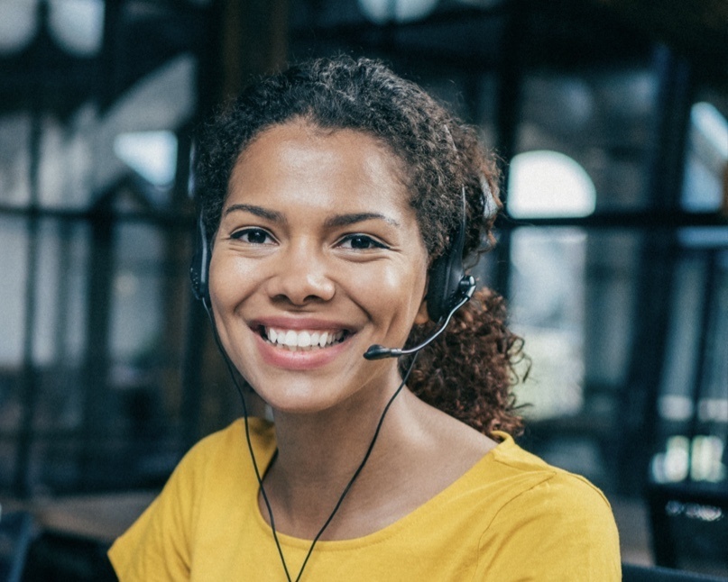 Image of customer service representative smiling and wearing a headset